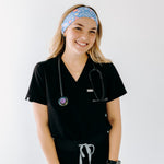 A nurse smiling with long hair while wearing the Born to Yap Forced to Chart headband for cute hairstyles and comfortable all-day wear.