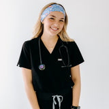 A nurse smiling with long hair while wearing the Born to Yap Forced to Chart headband for cute hairstyles and comfortable all-day wear.