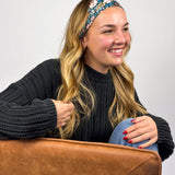 Woman wearing the Keely Floral on Black headband, showcasing its versatile 3-in-1 twist style and buttery-soft, non-slip fabric, ideal for work or play.