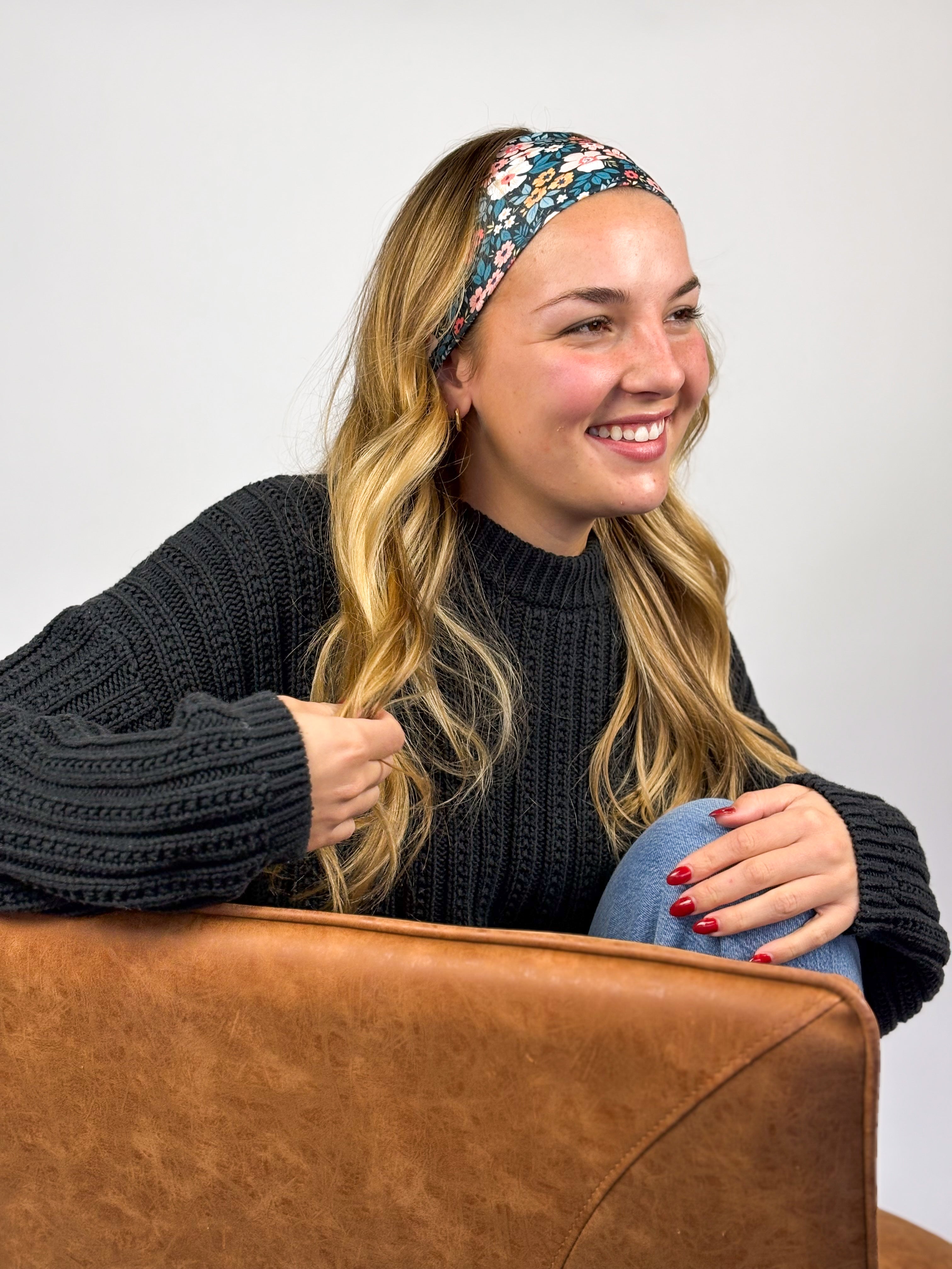 Woman wearing the Keely Floral on Black headband, showcasing its versatile 3-in-1 twist style and buttery-soft, non-slip fabric, ideal for work or play.