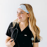A nurse smiling with long hair while wearing the Nurses Do It Better headband for cute hairstyles and comfortable all-day wear.