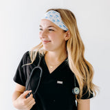 A nurse smiling with long hair while wearing the Nurses Do It Better headband for cute hairstyles and comfortable all-day wear.