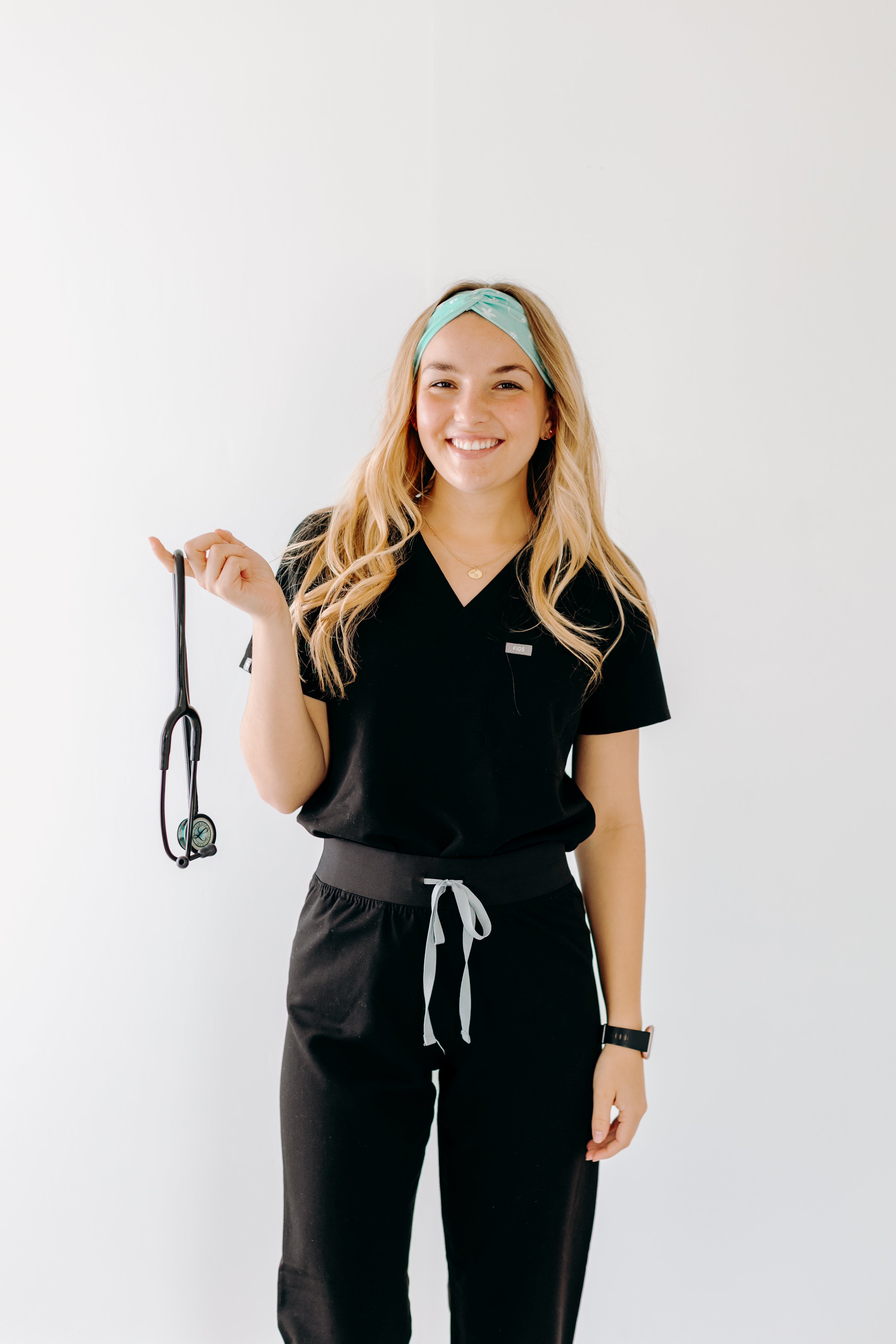 A nurse smiling with long hair while wearing the Undiagnosed But We're Pretty Sure headband for cute hairstyles and comfortable all-day wear.