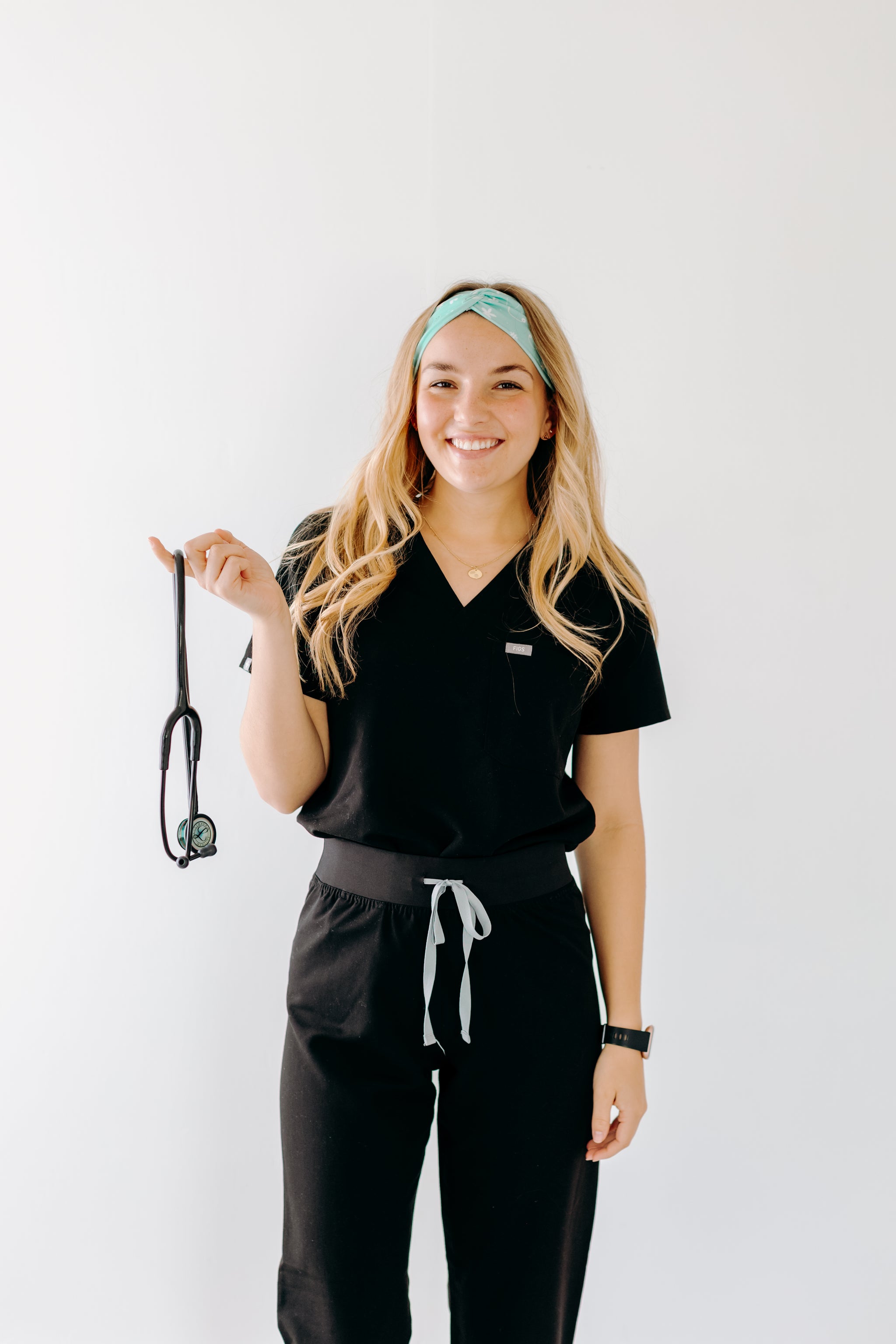 A nurse smiling with long hair while wearing the Undiagnosed But We're Pretty Sure headband for cute hairstyles and comfortable all-day wear.