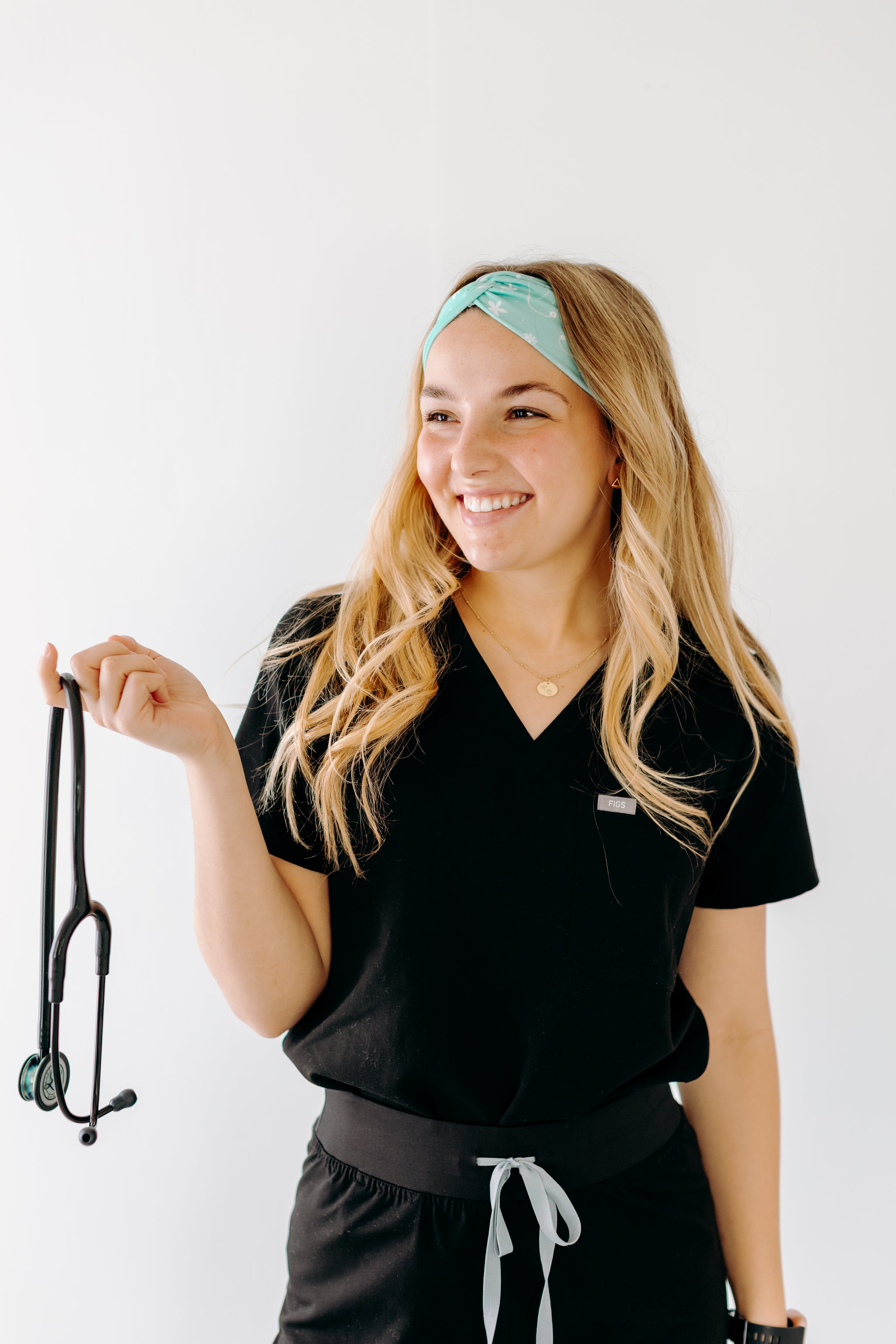 A nurse smiling with long hair while wearing the Undiagnosed But We're Pretty Sure headband for cute hairstyles and comfortable all-day wear.