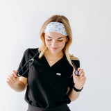 A nurse smiling with long hair while wearing the Nurses Do It Better headband for cute hairstyles and comfortable all-day wear.