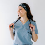 A nurse smiling with long hair while wearing the Gimme Some Space for cute hairstyles and comfortable all-day wear.