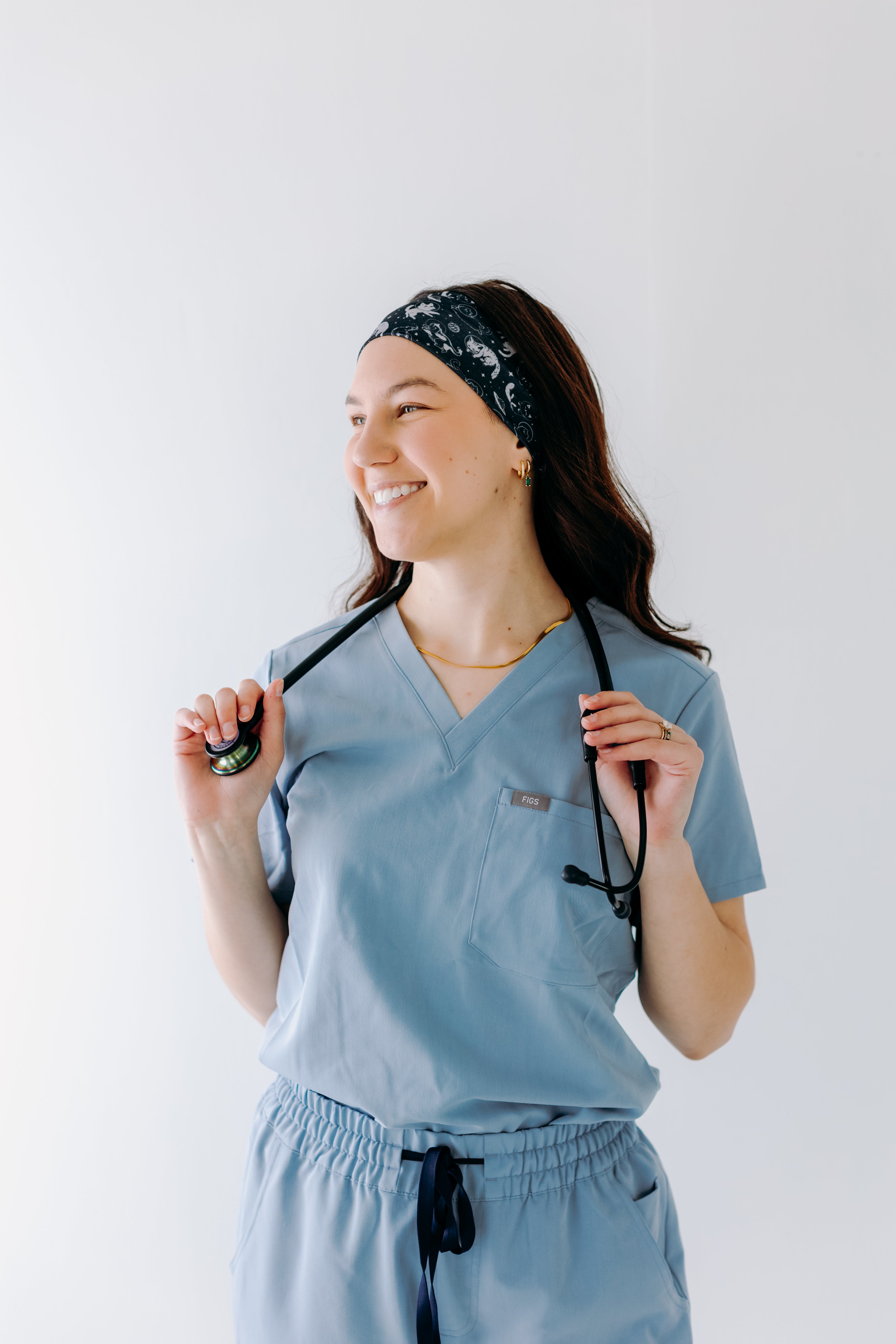 A nurse smiling with long hair while wearing the Gimme Some Space for cute hairstyles and comfortable all-day wear.