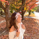 Woman smiling confidently in front of a tree, wearing the Sweet as Pie headband by Lilac Market Headbands, showcasing its versatile, non-slip design.