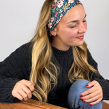 Woman wearing the Keely Floral on Black headband, showcasing its versatile 3-in-1 twist style and buttery-soft, non-slip fabric, ideal for work or play.