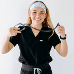 A nurse smiling with long hair while wearing the Nurses Do It Better headband for cute hairstyles and comfortable all-day wear.