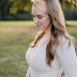 Woman smiling outdoors, wearing the Bring the Weather headband from The Jen Hamilton Collection, showcasing its versatile, non-slip, buttery-soft design.