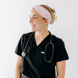 A nurse smiling with hair pinned up while wearing the I'm Just Here For The Free Gloves headband for cute hairstyles and comfortable all-day wear.