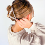 A woman with long hair wearing the A Different Angle Lilac Clip, a glossy hair accessory with a hinge closure.