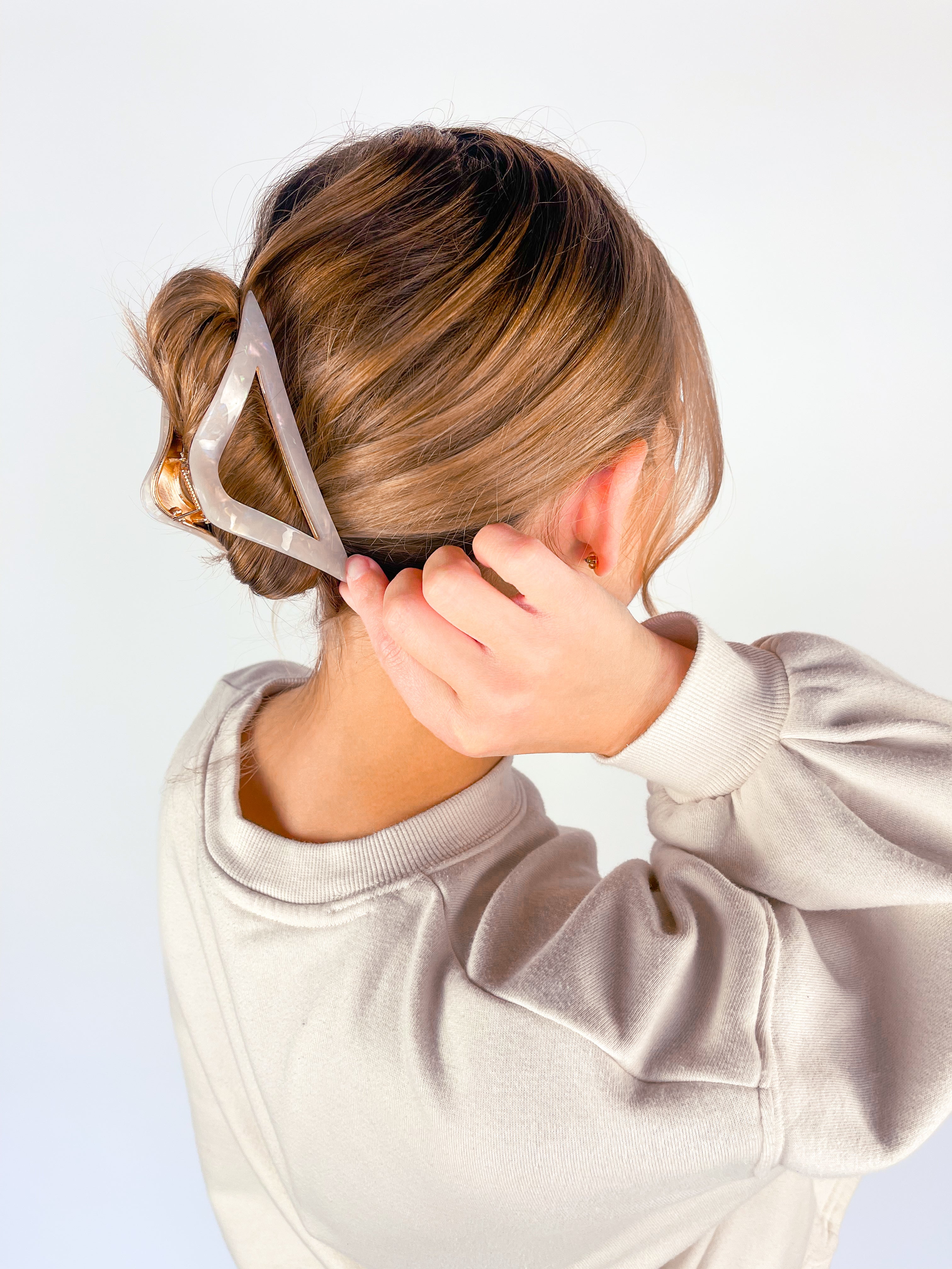 A woman with long hair wearing the A Different Angle Lilac Clip, a glossy hair accessory with a hinge closure.