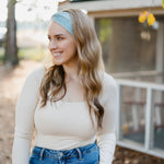 Beautifully Unconventional headband, worn by a smiling woman with long hair, showcasing its versatile 3-in-1 twist style and comfortable fit from the Jen Hamilton Collection.