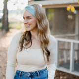 Beautifully Unconventional headband, worn by a smiling woman with long hair, showcasing its versatile 3-in-1 twist style and comfortable fit from the Jen Hamilton Collection.
