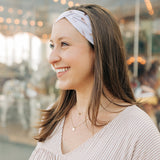 Woman smiling, wearing The Corey headband, a versatile and functional poly-knit blend from The Sarah Wallace Collection, the perfect accessory for easy hairstyles.
