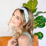 A woman confidently wearing the Don't Worry, Be Hoppy mint green headband with rabbits and flowers. An accessory for style and function, whether work or play.