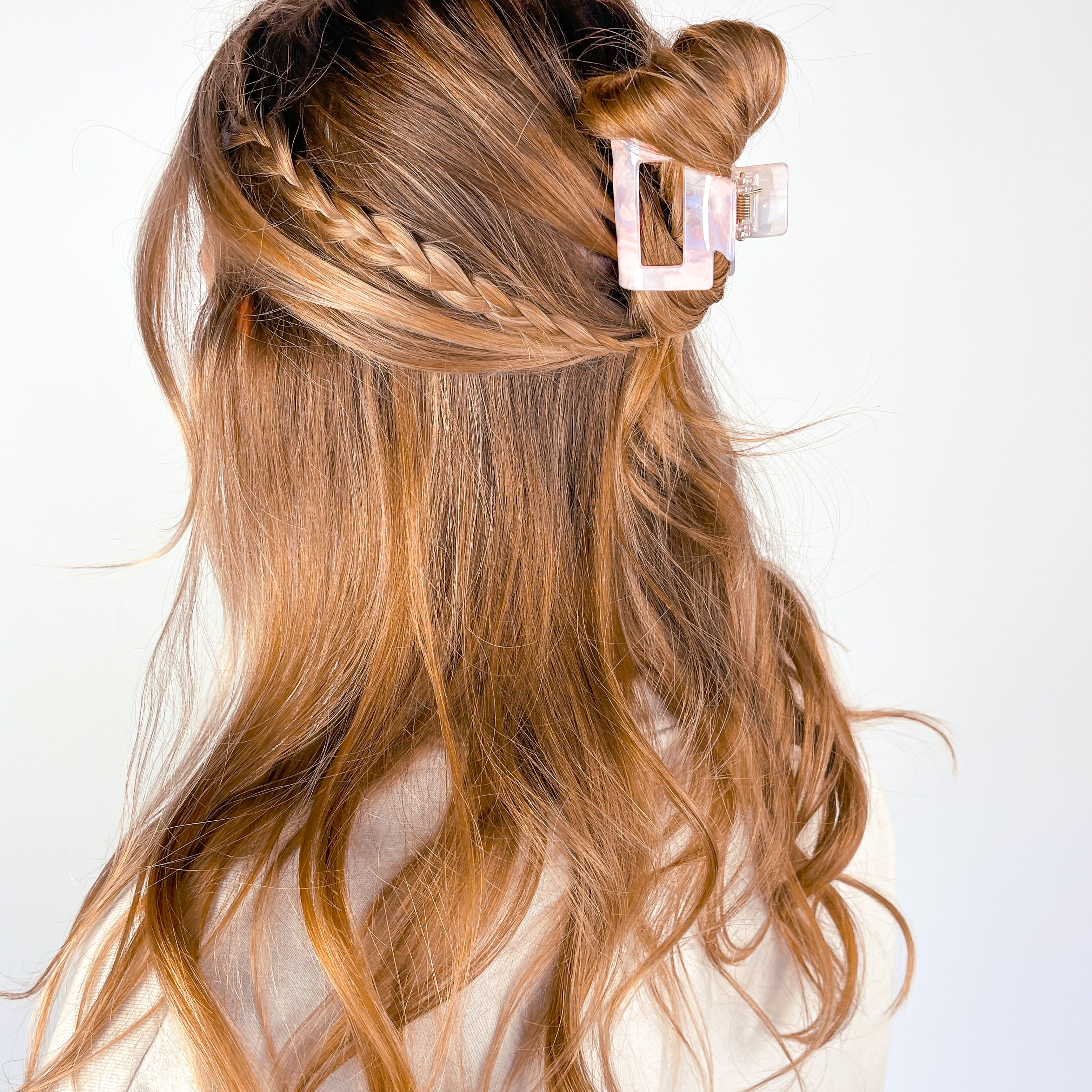 A woman wearing the Head in the Clouds Lilac Clip, a 2-inch long claw clip, adding style to her hair.