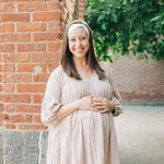 A woman smiling and confidently wearing the Springtime in Brooklyn headband from The Sarah Wallace Collection, showcasing its versatile twist style and non-slip design.