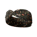 The Enchanted Garden black headband features books and plants design, made from a soft, stretchy poly-knit blend for versatile, non-slip wear.