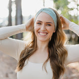 Beautifully Unconventional headband, worn by a smiling woman with long hair, showcasing its versatile 3-in-1 twist style and comfortable fit from the Jen Hamilton Collection.