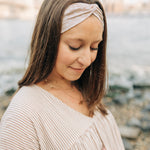 Woman wearing Unconditional headband from The Sarah Wallace Collection. Headband is versatile, non-slip, and sweat absorbent, perfect for various activities.