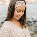 Woman wearing Unconditional headband from The Sarah Wallace Collection. Headband is versatile, non-slip, and sweat absorbent, perfect for various activities.