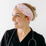 A nurse smiling with hair pinned up while wearing the I'm Just Here For The Free Gloves headband for cute hairstyles and comfortable all-day wear.