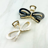 Treat Yourself Lilac Clip, a glossy 4-inch claw clip with hinge closure, available in two color options of white or black, perfect for keeping hair in place.