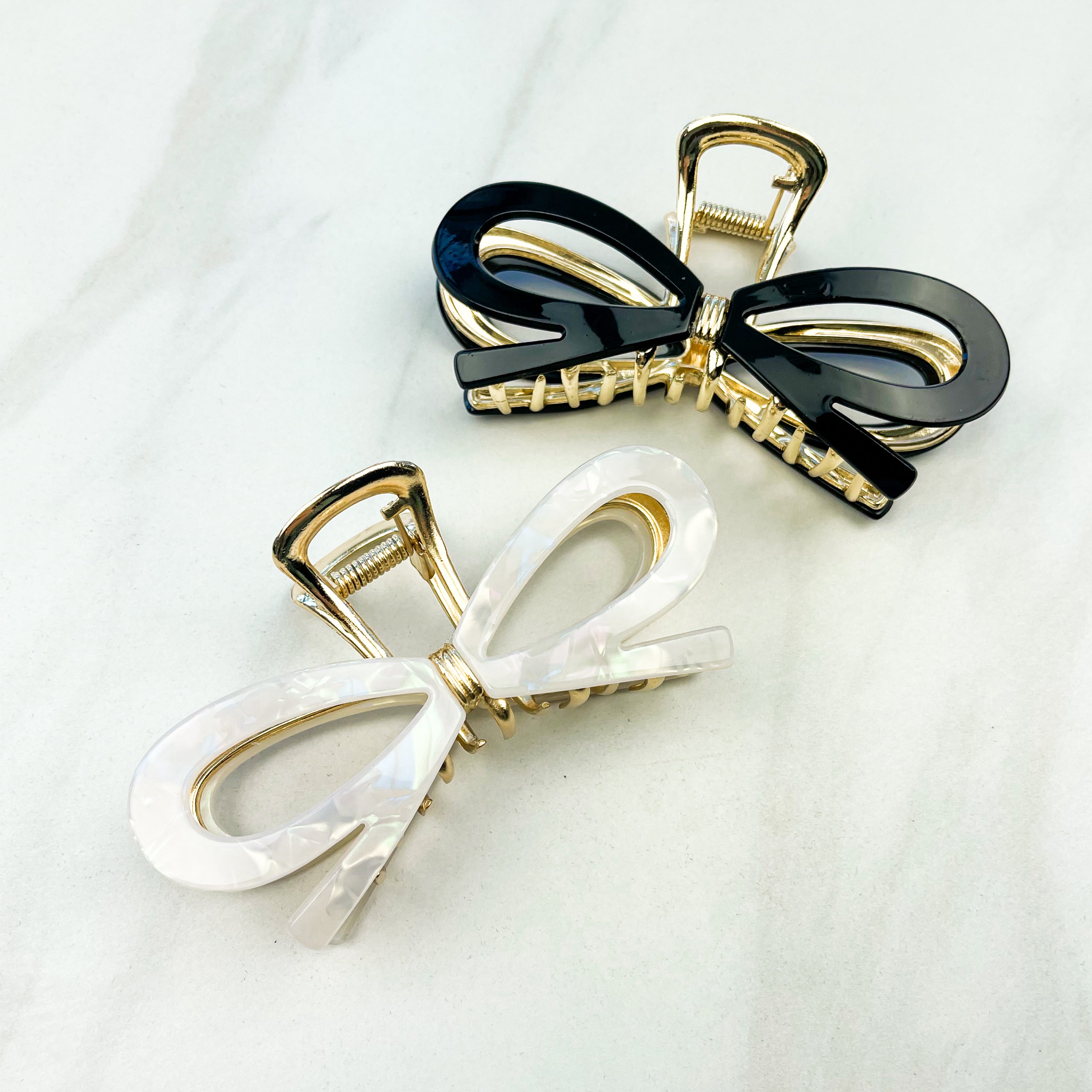 Treat Yourself Lilac Clip, a glossy 4-inch claw clip with hinge closure, available in two color options of white or black, perfect for keeping hair in place.