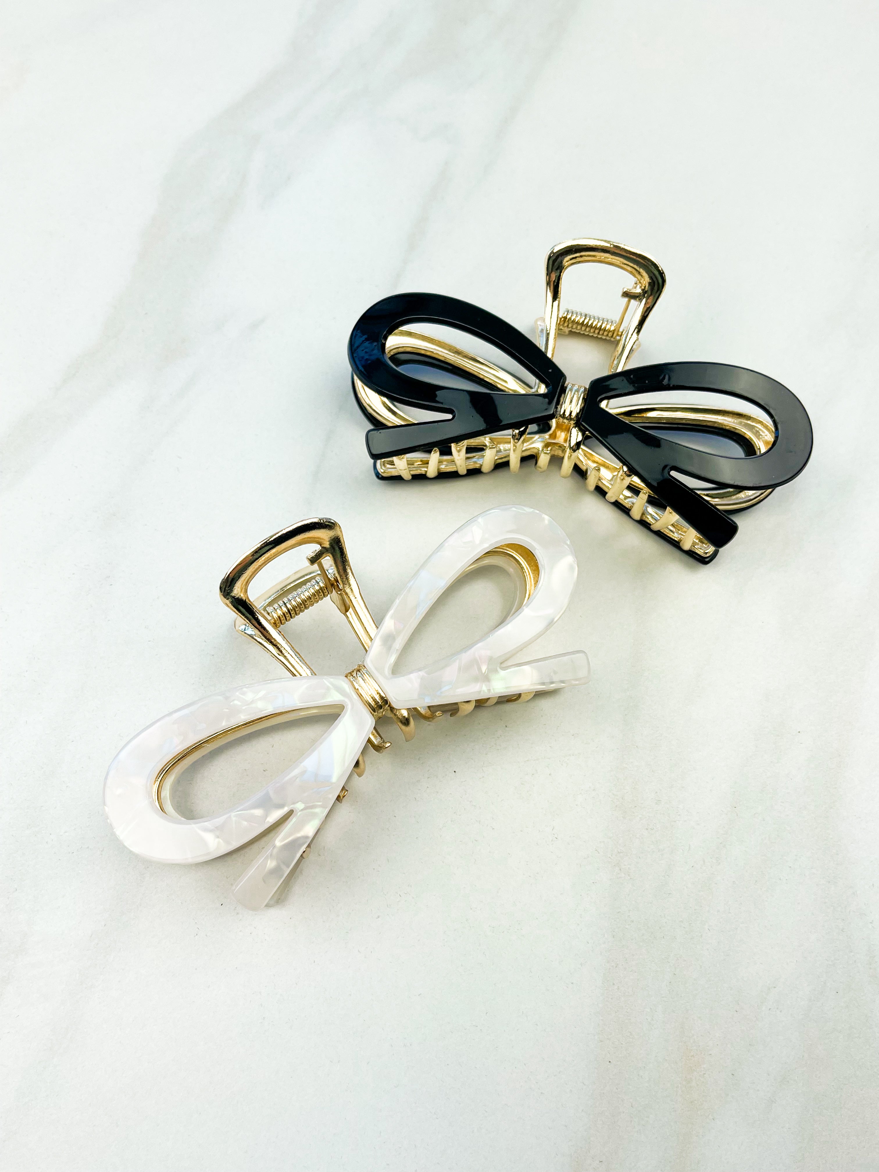 Treat Yourself Lilac Clip, a glossy 4-inch claw clip with hinge closure, available in two color options of white or black, perfect for keeping hair in place.