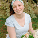 Woman smiling while wearing the Hope Floral on Ivory headband, the perfect non-slip accessory for work or workouts.