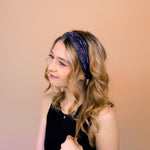 A woman wearing the Better in Black headband, a functional and versatile accessory for workouts, shifts, and play days.