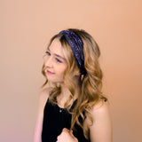 A woman wearing the Better in Black headband, a functional and versatile accessory for workouts, shifts, and play days.