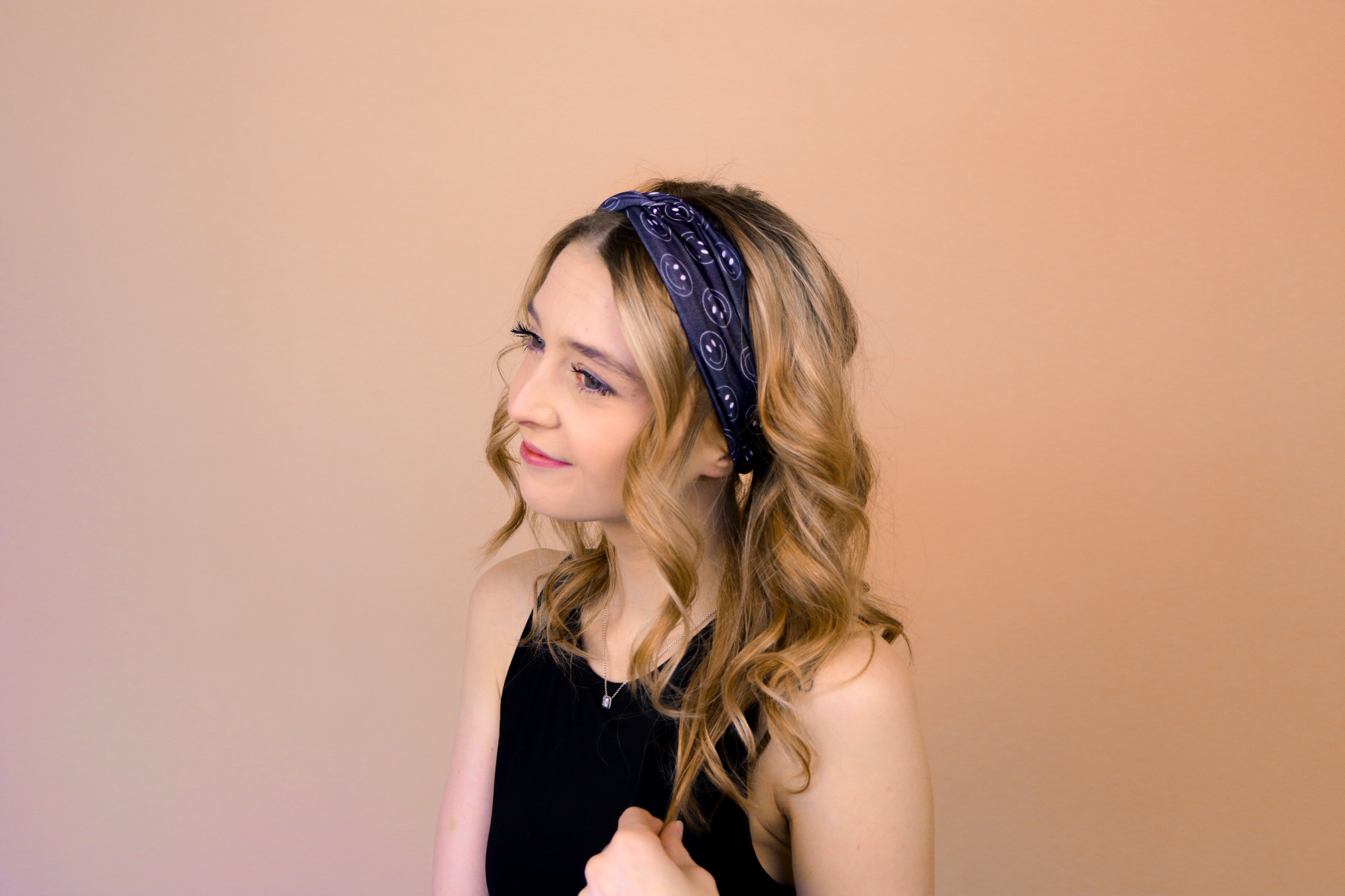 A woman wearing the Better in Black headband, a functional and versatile accessory for workouts, shifts, and play days.