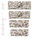 Group of EST. 1923 - Mommy & Me twist knot headbands, featuring floral Mickey Mouse patterns, various sizes for adults, children, and adjustable bow pieces for toddlers and babies.