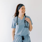 A nurse smiling with long hair while wearing the Gimme Some Space for cute hairstyles and comfortable all-day wear.