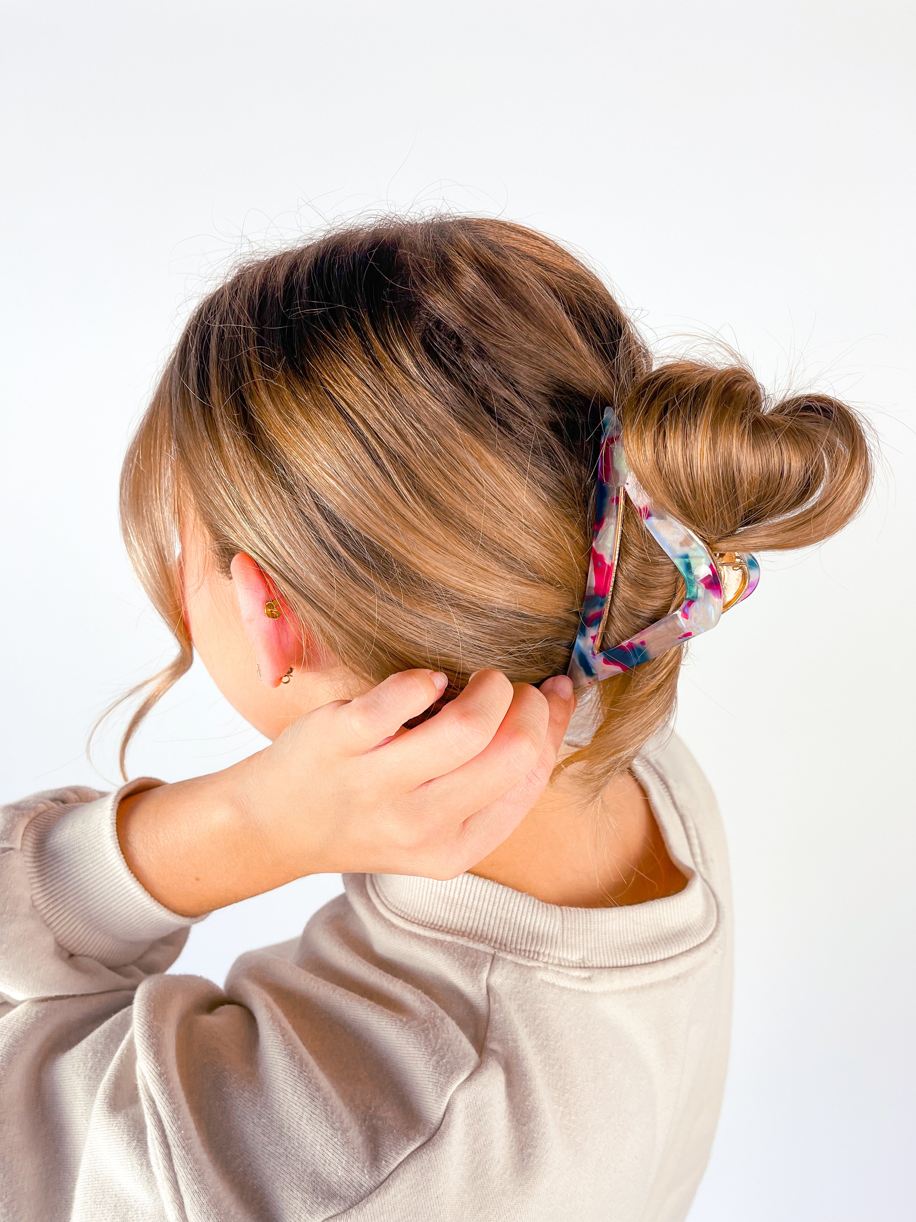 A woman with long hair wearing the A Different Angle Lilac Clip, a glossy hair accessory with a hinge closure.