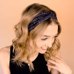 A woman wearing the Better in Black headband, a functional and versatile accessory for workouts, shifts, and play days.