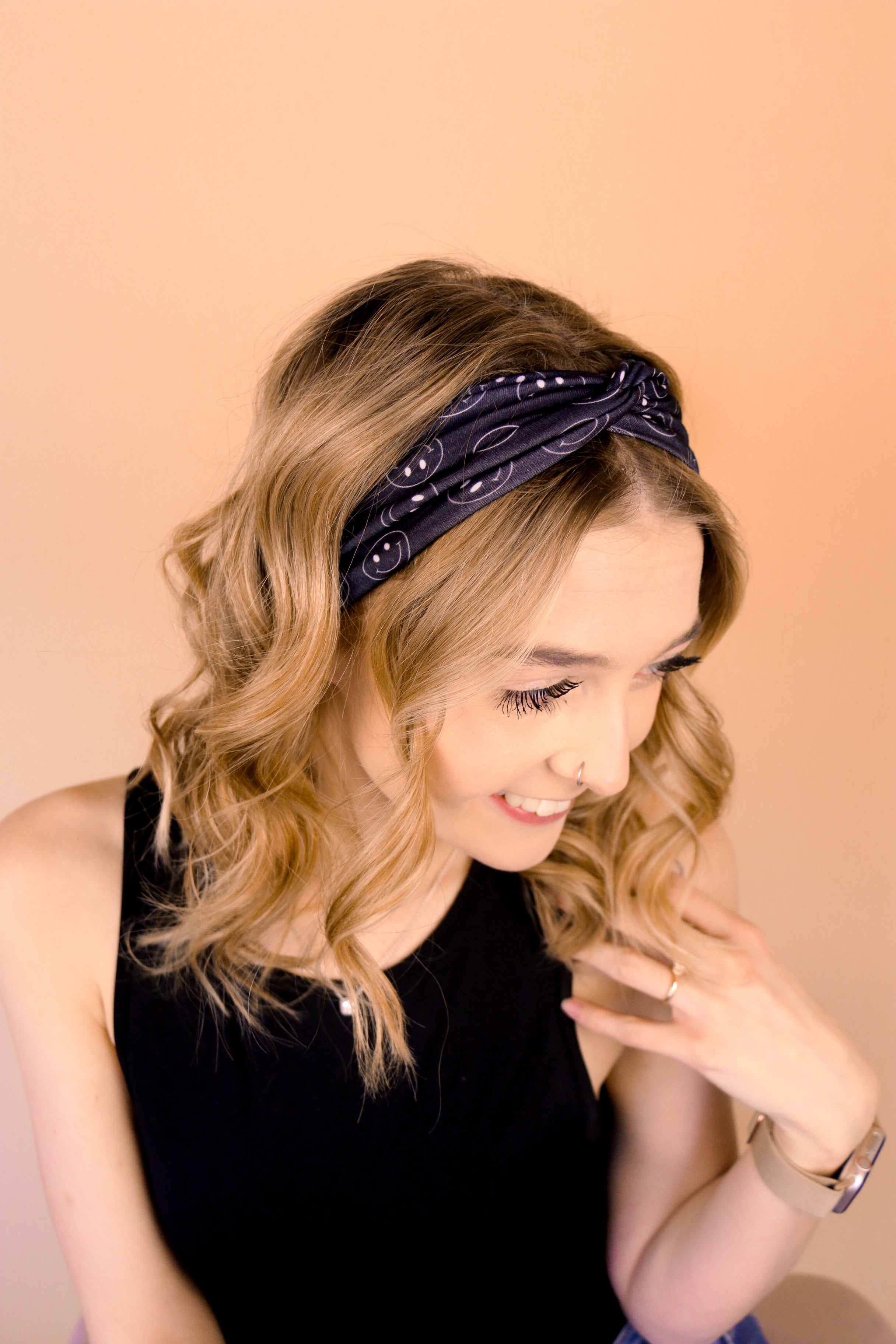 A woman wearing the Better in Black headband, a functional and versatile accessory for workouts, shifts, and play days.