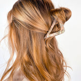 A woman with long hair wearing the A Different Angle Lilac Clip, a glossy hair accessory with a hinge closure.