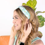 A woman confidently wearing the Don't Worry, Be Hoppy mint green headband with rabbits and flowers. An accessory for style and function, whether work or play.