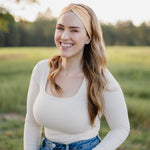 Woman smiling outdoors, wearing the Bring the Weather headband from The Jen Hamilton Collection, showcasing its versatile, non-slip, buttery-soft design.