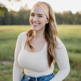 Woman smiling outdoors, wearing the Bring the Weather headband from The Jen Hamilton Collection, showcasing its versatile, non-slip, buttery-soft design.