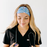 A nurse smiling with long hair while wearing the Born to Yap Forced to Chart headband for cute hairstyles and comfortable all-day wear.