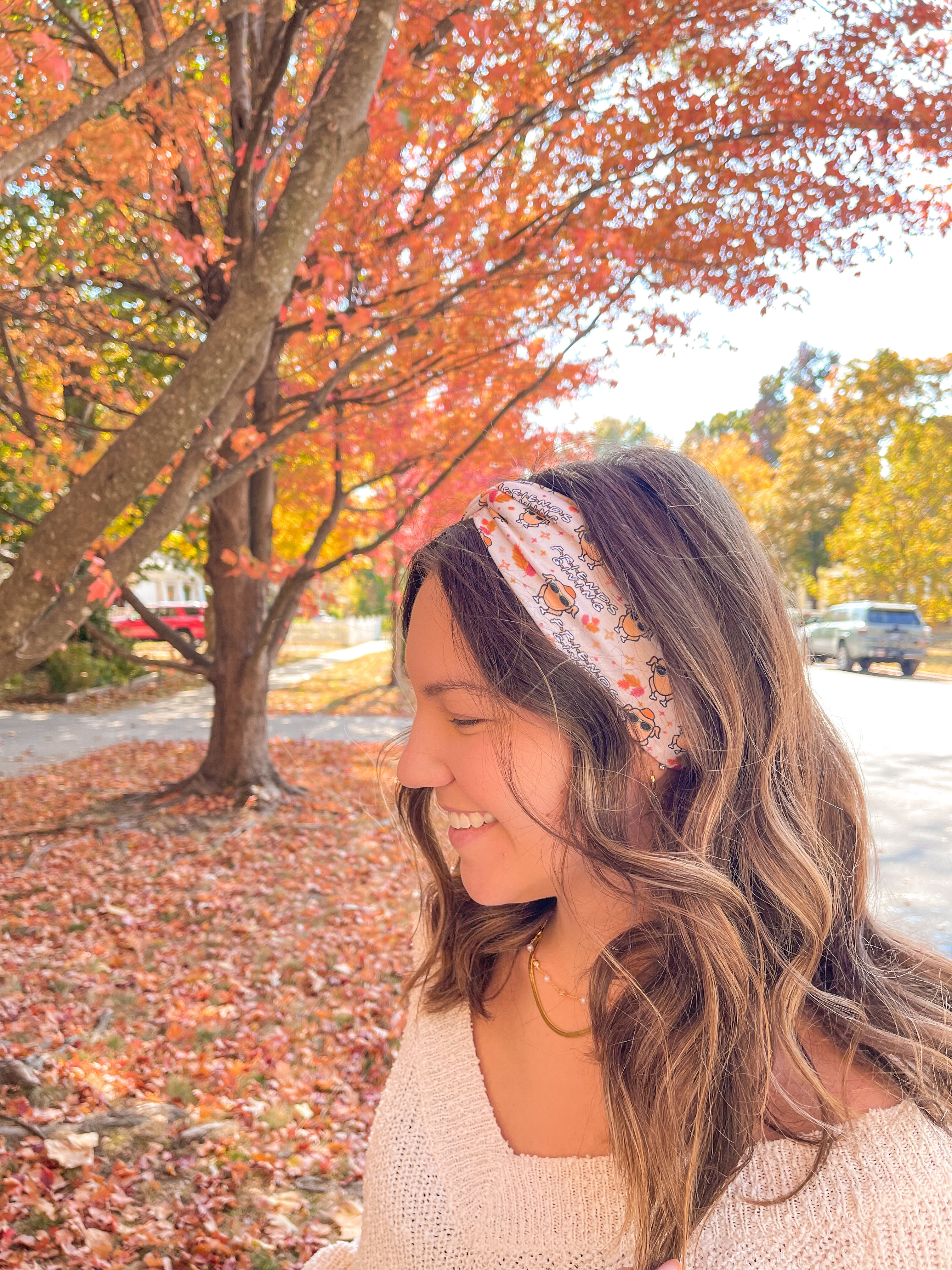 Woman wearing The One With All the Thanksgivings headband, smiling with her easy hairstyle. The headband is versatile, non-slip, and perfect for various activities.