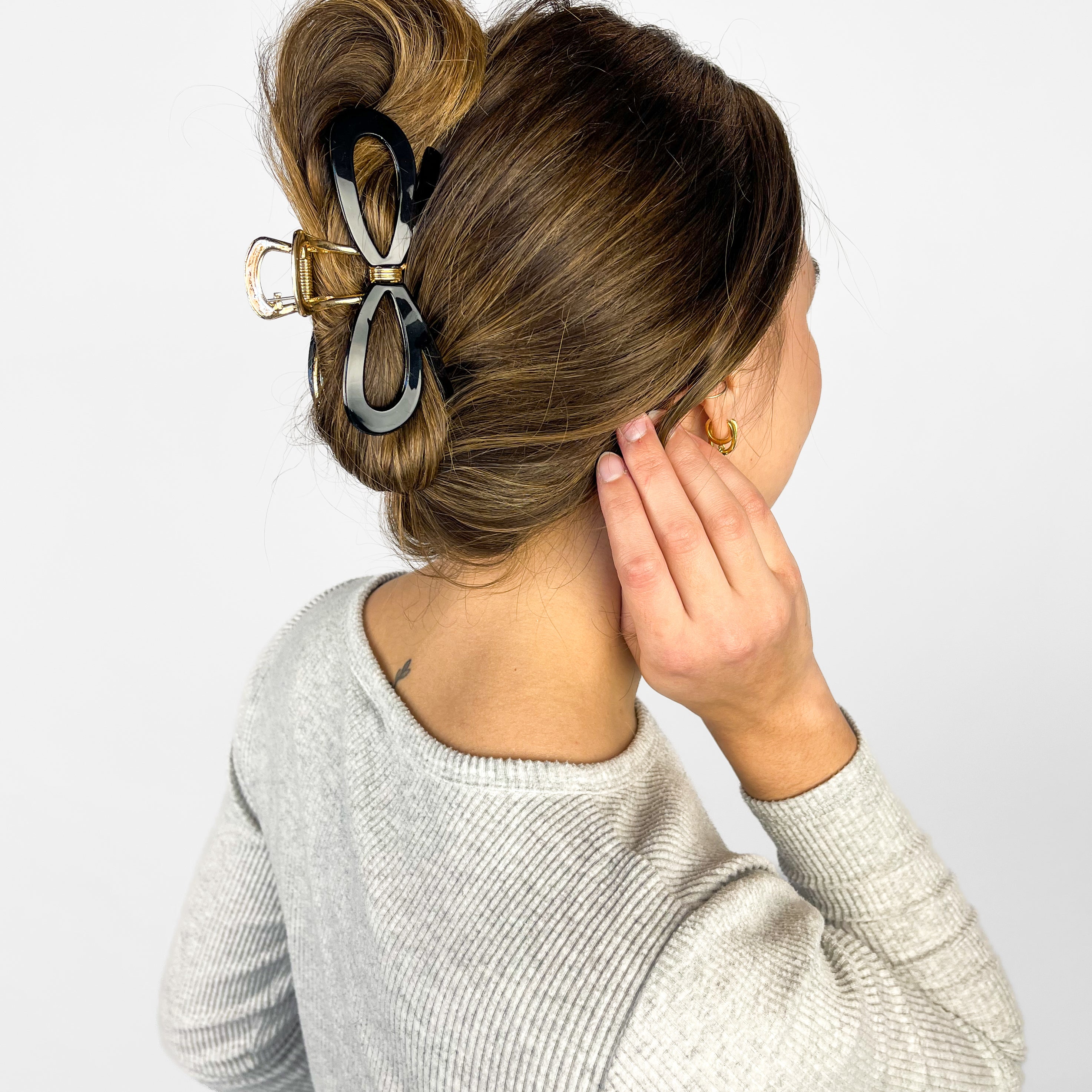 Woman confidently wearing the Treat Yourself Lilac Clip in her hair, featuring a 4-inch glossy metal claw design with hinge closure, styled in a twist.