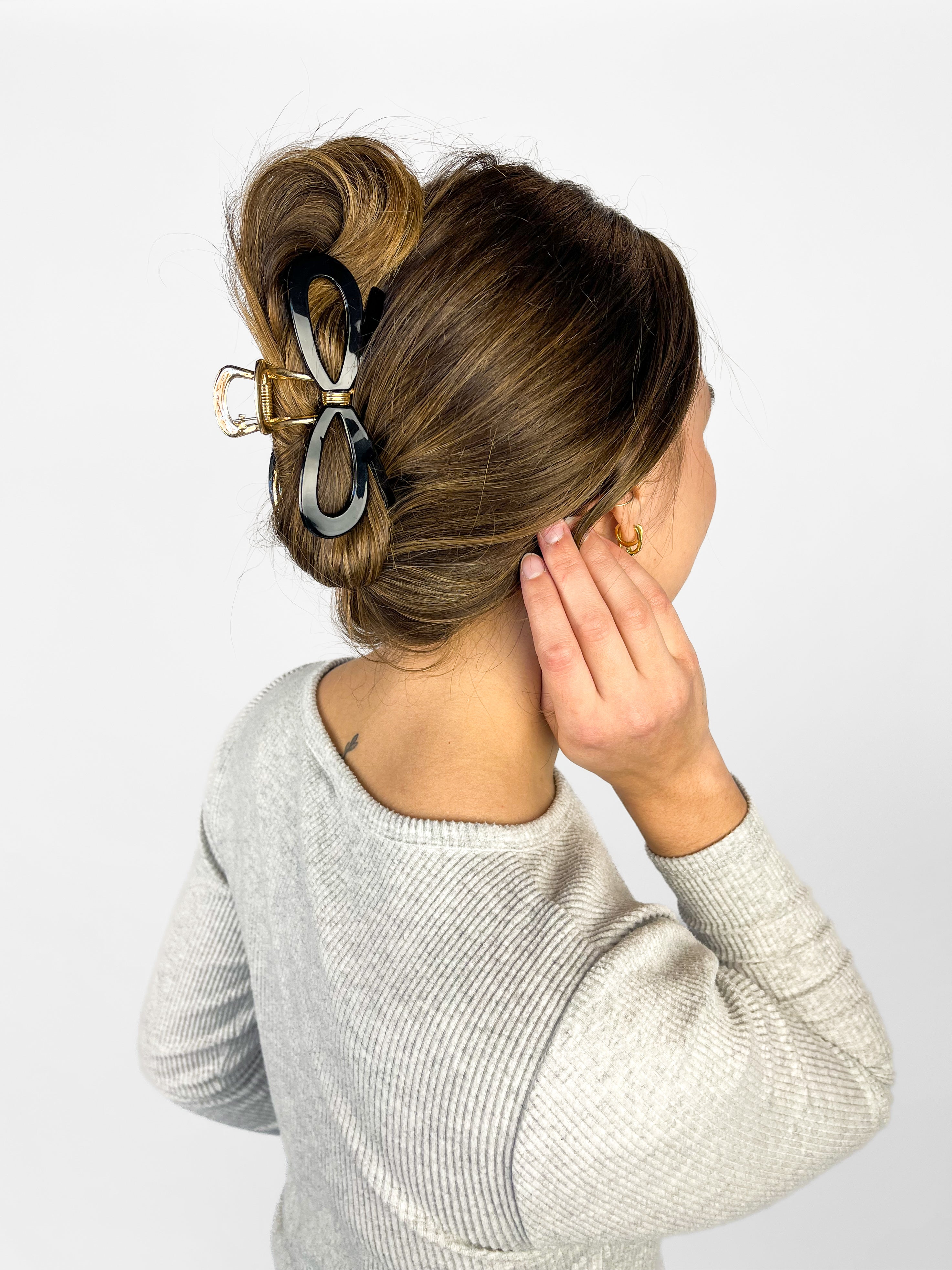 Woman confidently wearing the Treat Yourself Lilac Clip in her hair, featuring a 4-inch glossy metal claw design with hinge closure, styled in a twist.
